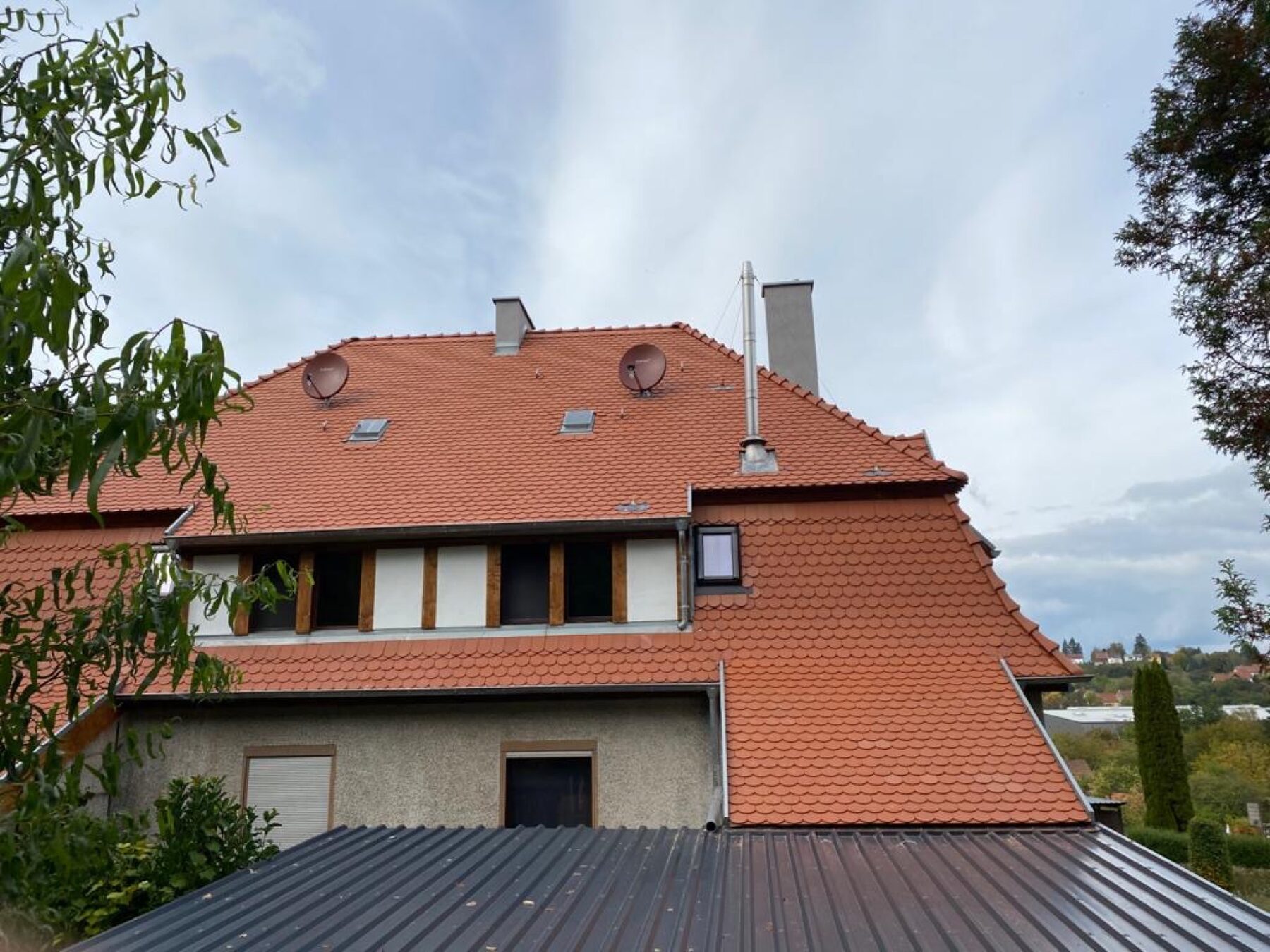 Großes Altbau-Walmdach in orange-rot mit Detailansicht