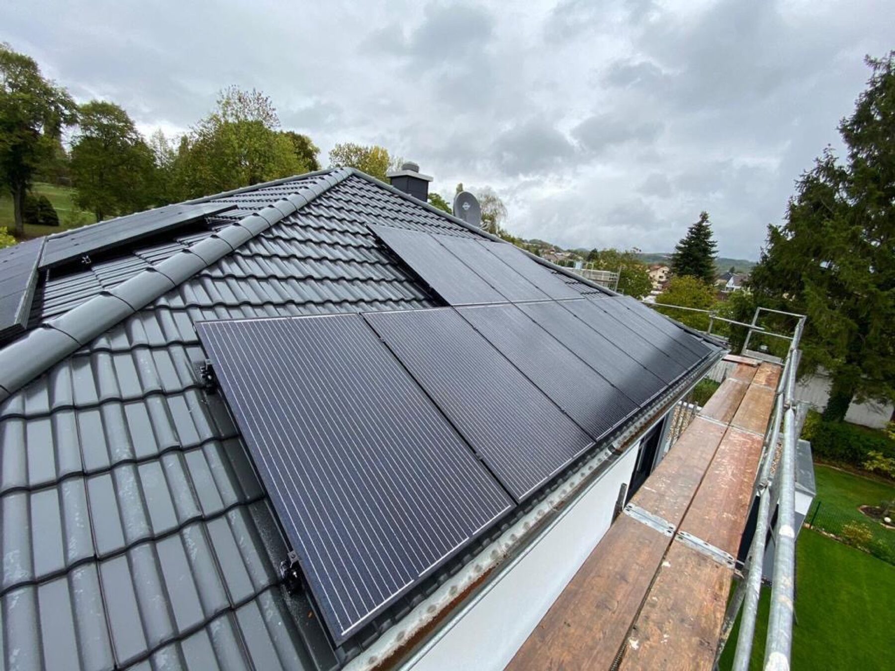 PV-Anlage auf anthrazitfarbenem Walmdach mit Gerüstaufstieg