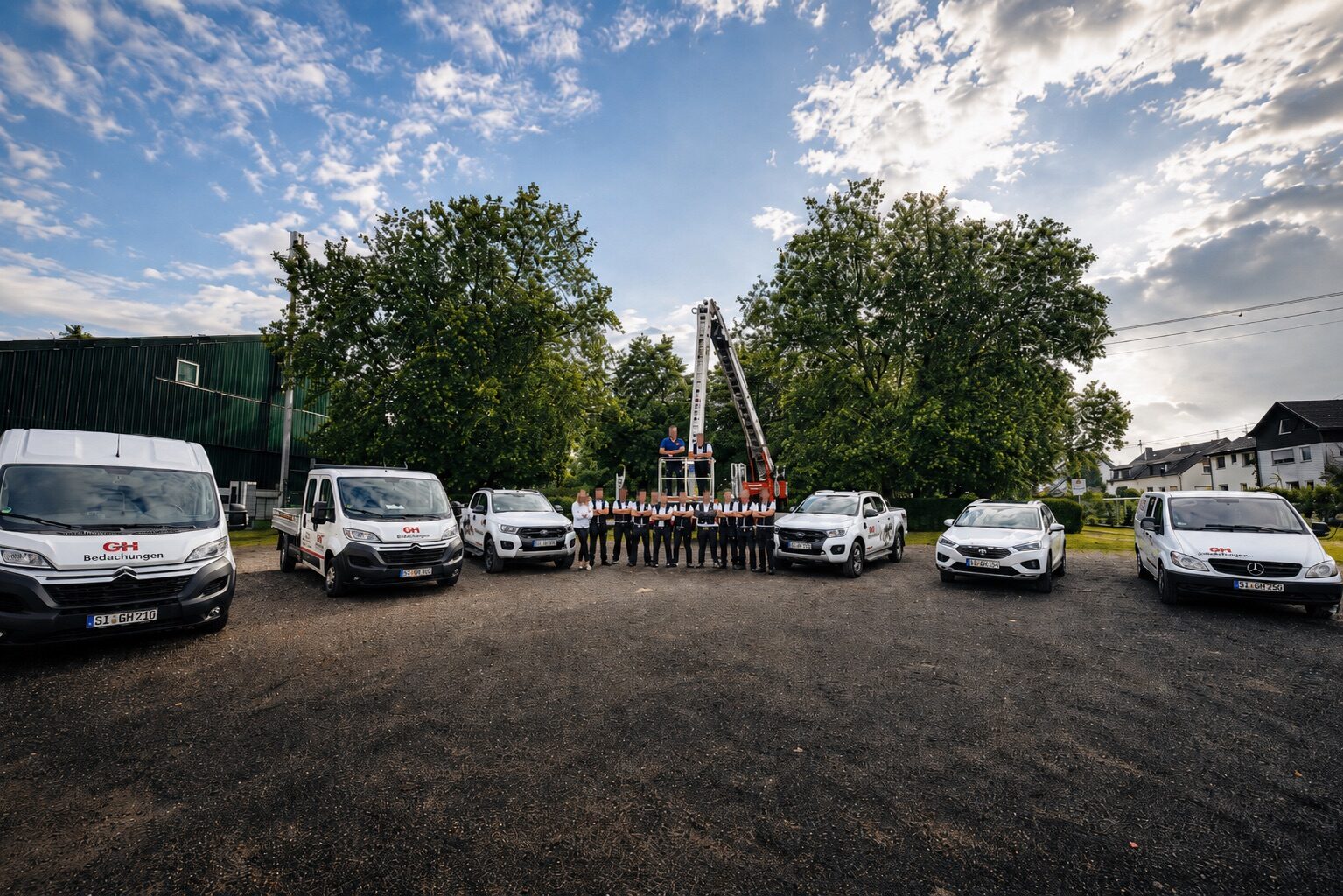 Komplettes Team mit Fahrzeugflotte vor dramatischer Wolkenkulisse